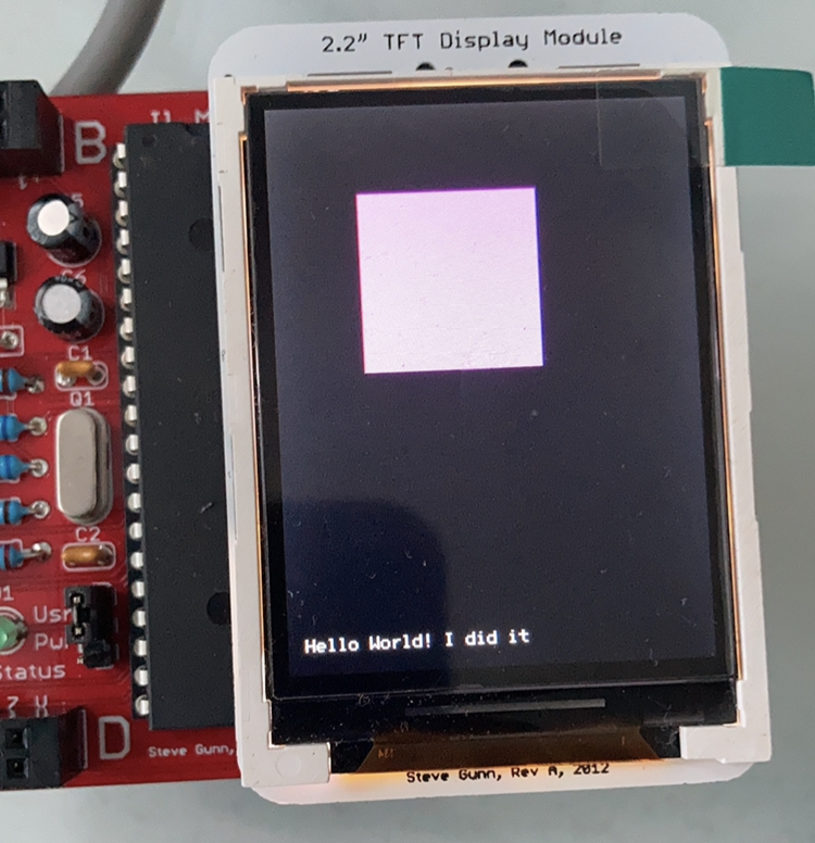 Microcontroller with tft screen showing a filled rectangle and Hello World text